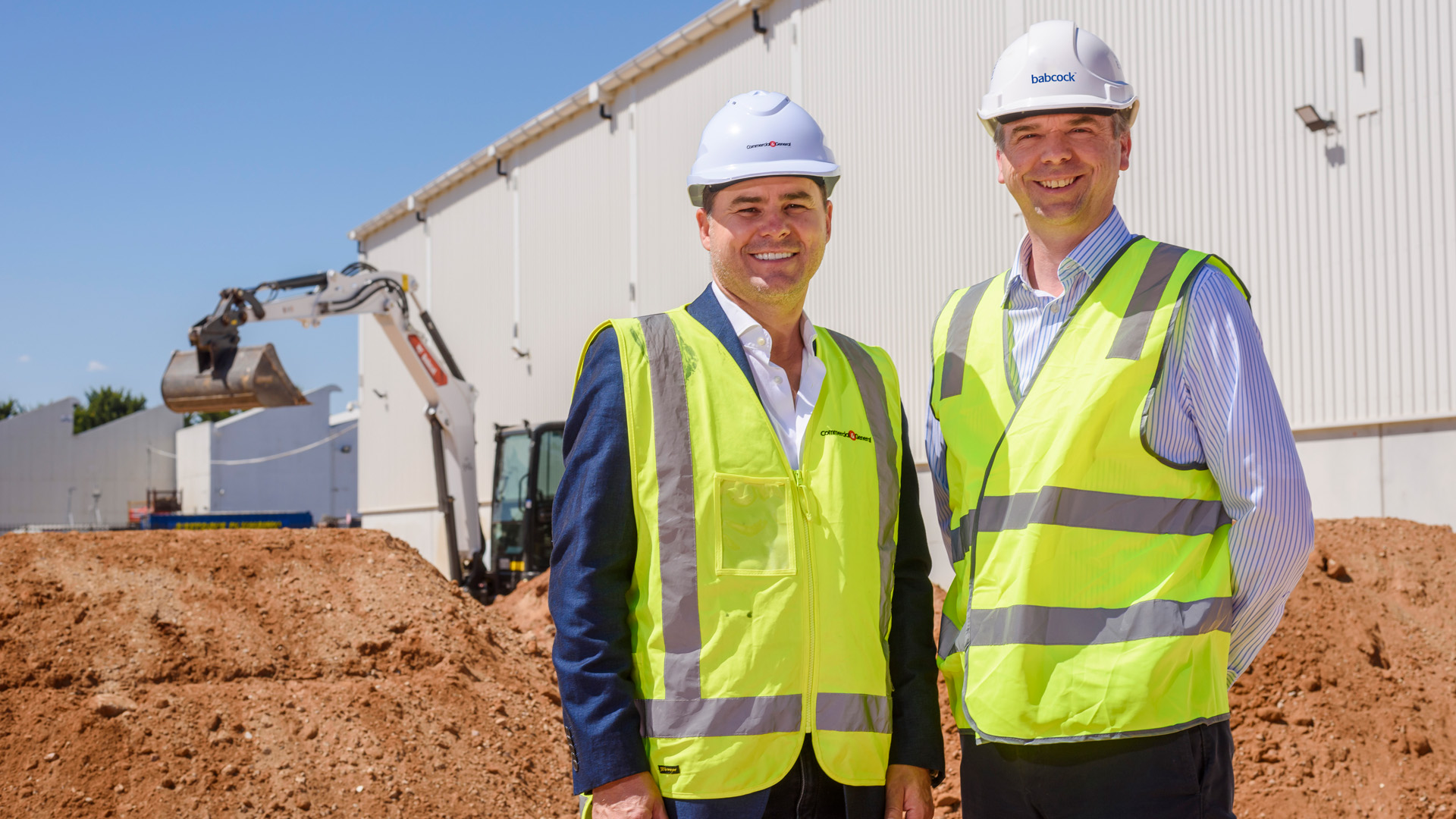 Two Babcock representatives standing at new construction site for facility expansion
